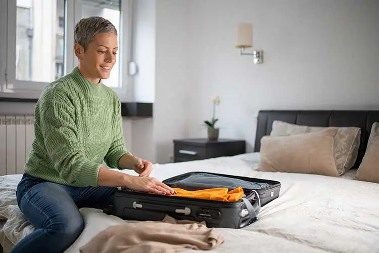 an adult woman packs her bags